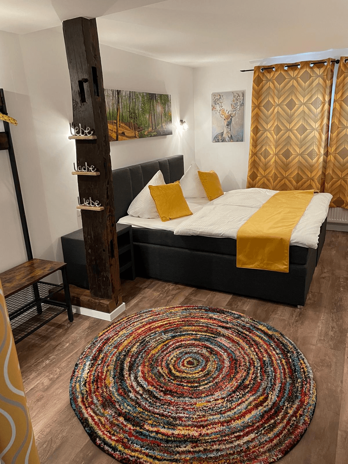 Doppelzimmer mit Boxspringbett und buntem Teppich